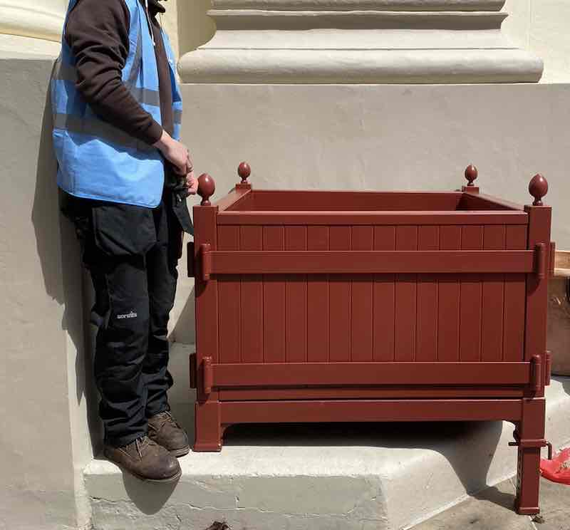 Roter großer massiver Metall Pflanzkübel auf Treppe