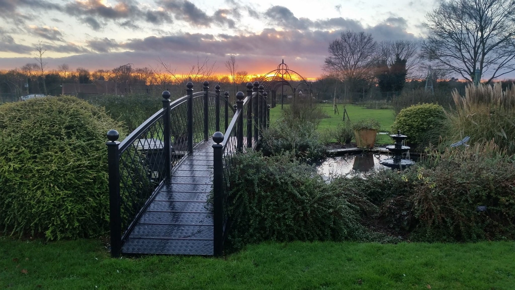 Metall Bogenbrücke Attleborough von Classic Garden Elements beim Sonnenuntergang im Garten von Peter Beales Roses