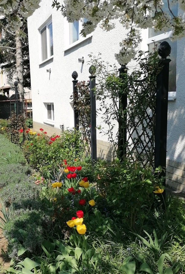 Trenngitter Paravent und Pfosten mit Pinienzepfen von Classic Garden Elements im Frühlingsgarten