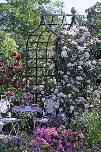 Viktorianische Rosenlaube von Classic Garden Elements mit Kletterrose 'New Dawn' und Sitzgruppe in Juni
