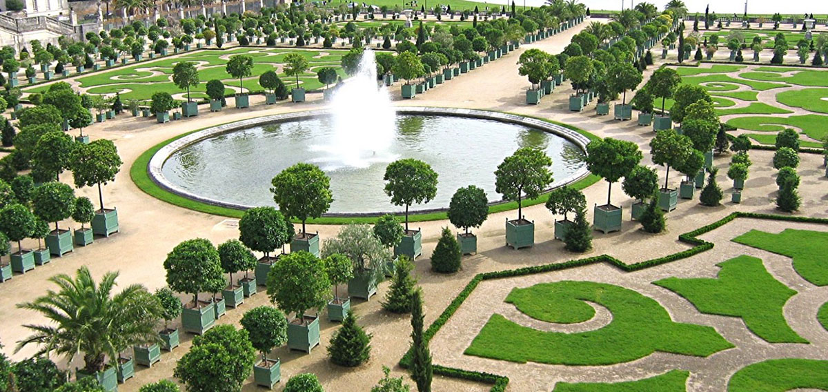 Parterre mit Springbrunnen und Versailler Pflanzkübeln an der Orangerie von Versailles