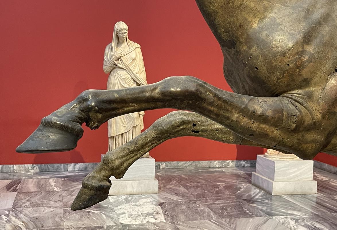 Artemisioni neemelt pärit ratsanik – esijalgade detail koos taustal oleva kujuga Artemisioni neemelt pärit ratsanik – esijalgade detail koos taustal oleva kujuga