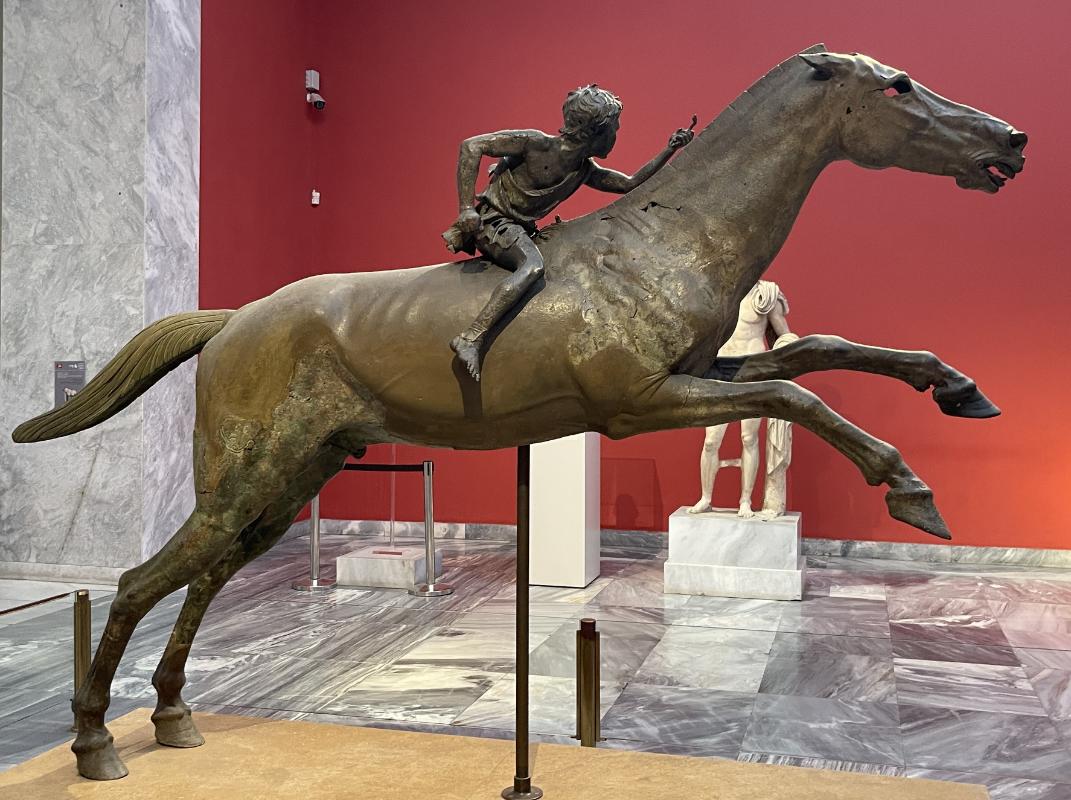 Artemisioni neeme ratsanik – pronkskuju külgvaade koos džokiga galopeeriva hobuse seljas Artemisioni neeme ratsanik – pronkskuju külgvaade koos džokiga galopeeriva hobuse seljas