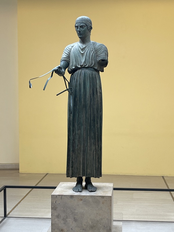 Wagenlenker von Delphi mit langer Tunika, die bis zu den Knöcheln reicht Wagenlenker von Delphi mit langer Tunika, die bis zu den Knöcheln reicht